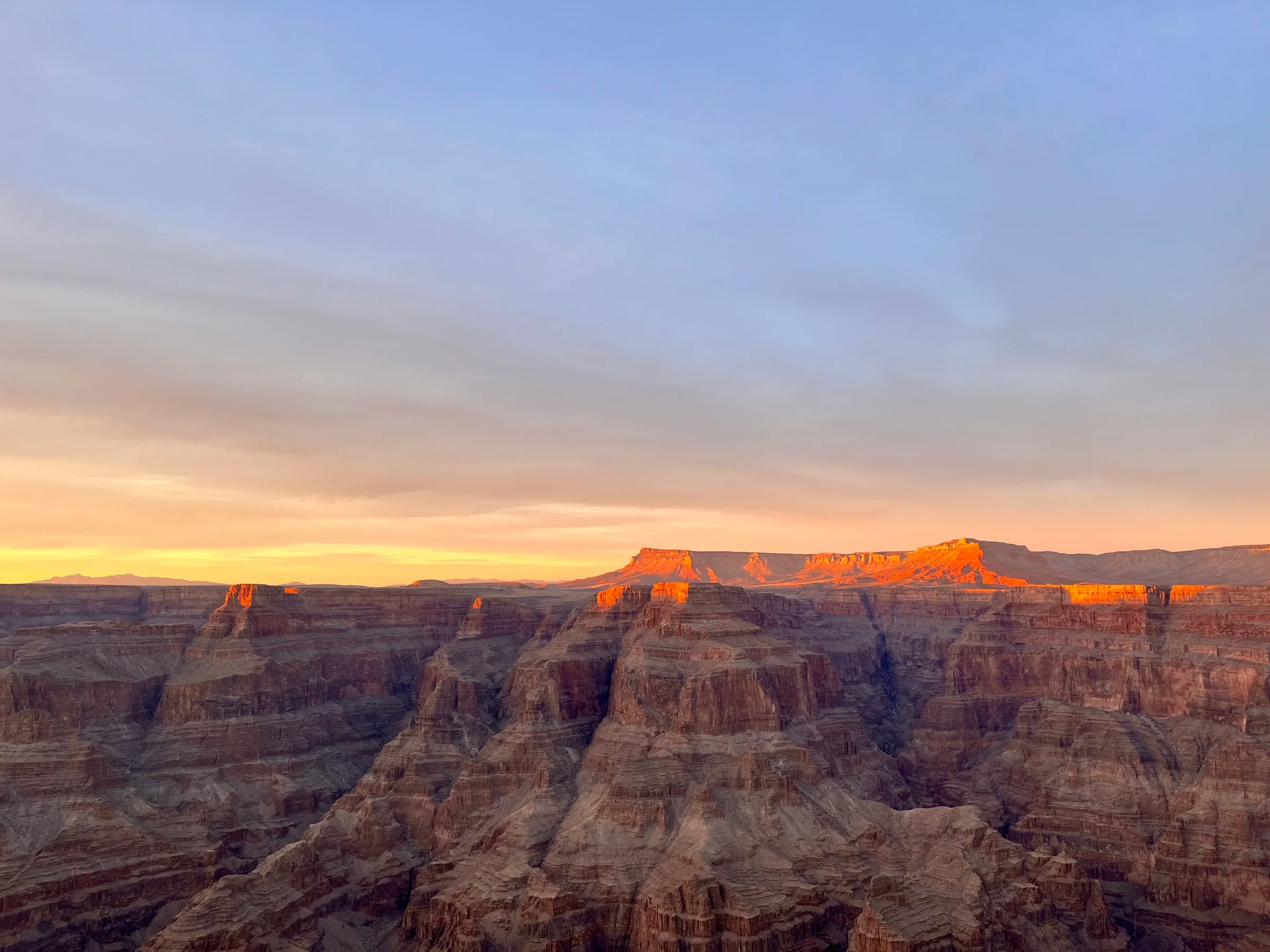 The sun setting over the layered walls of a vast Southwest canyon