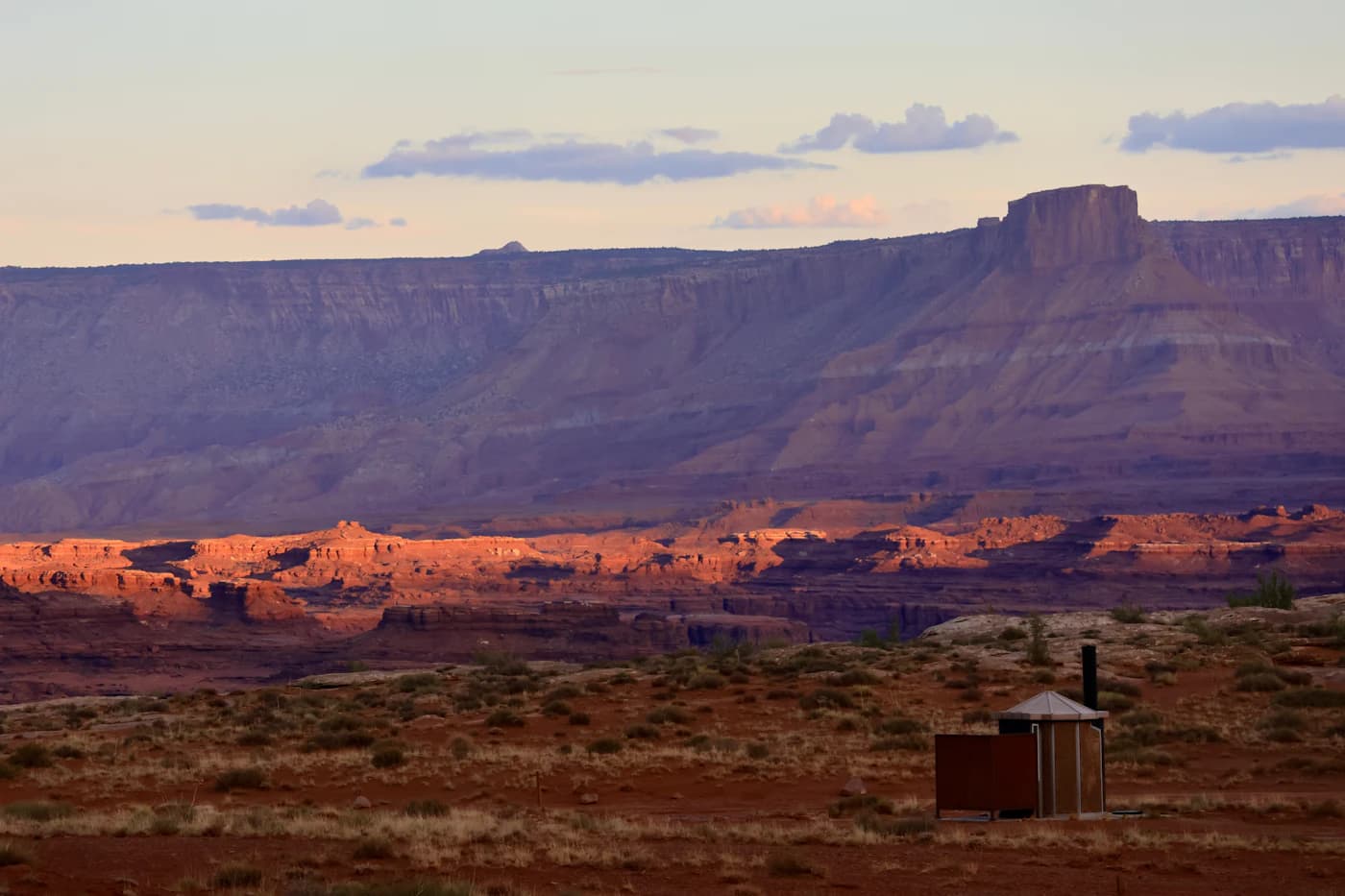 Desert plains leading to a distant mesa under a wide sky