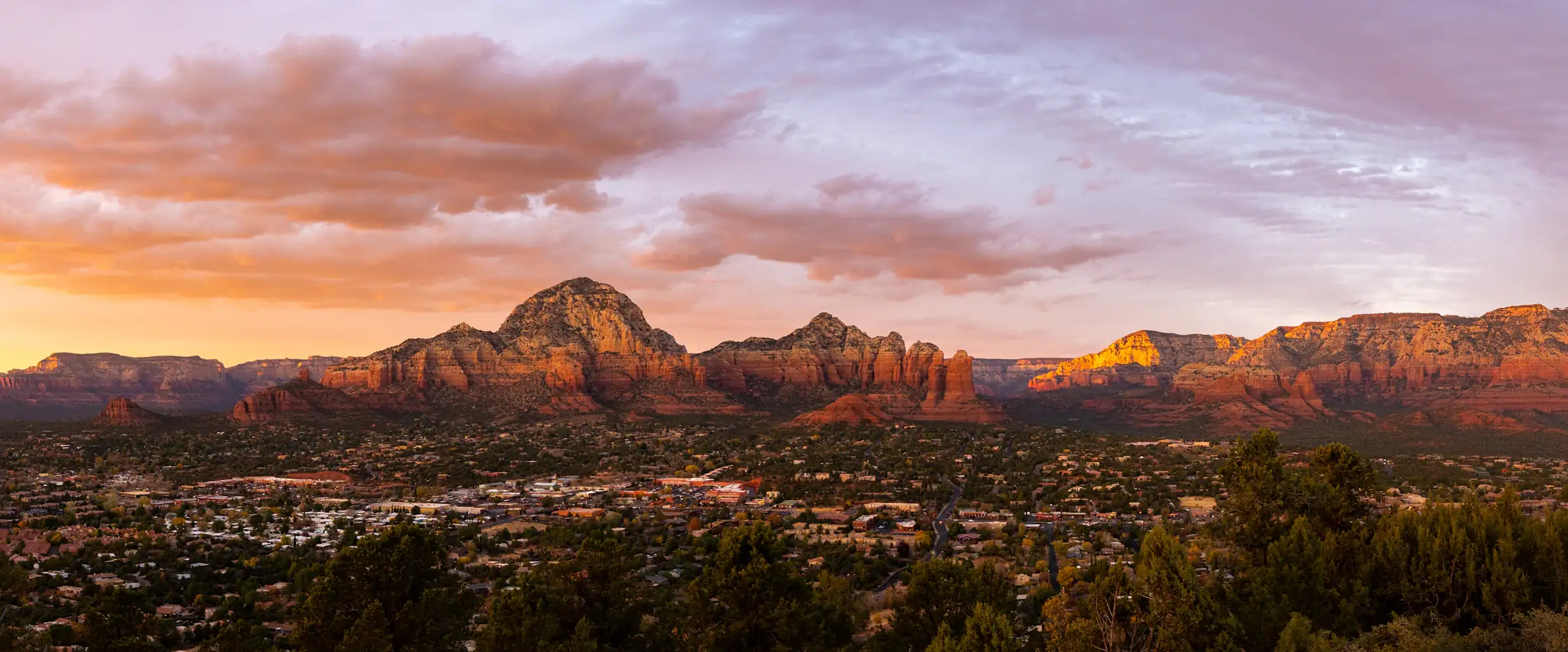 Sedona red rock mountains at sunset beneath a cloud-streaked sky